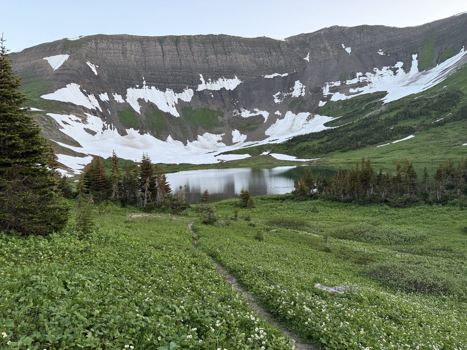 Windfall Lake below its snow-streaked headwall in the Tumbler Ridge UNESCO Global Geopark