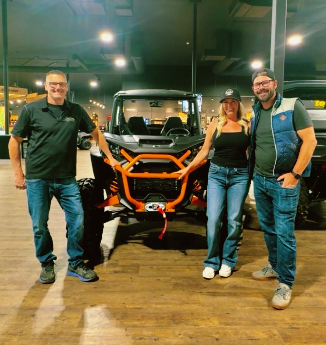 Roger from Stojan's handing over the Can-Am Commander to Stacie and Ryan on the showroom floor