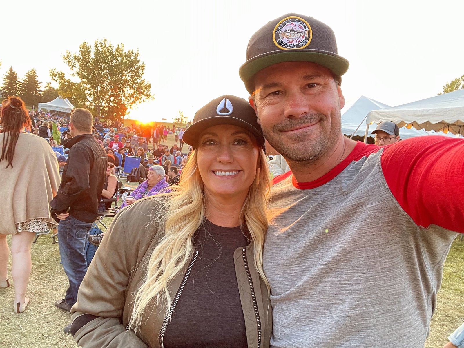 Stacie and Ryan together at an outdoor concert as the sun sets behind the crowd